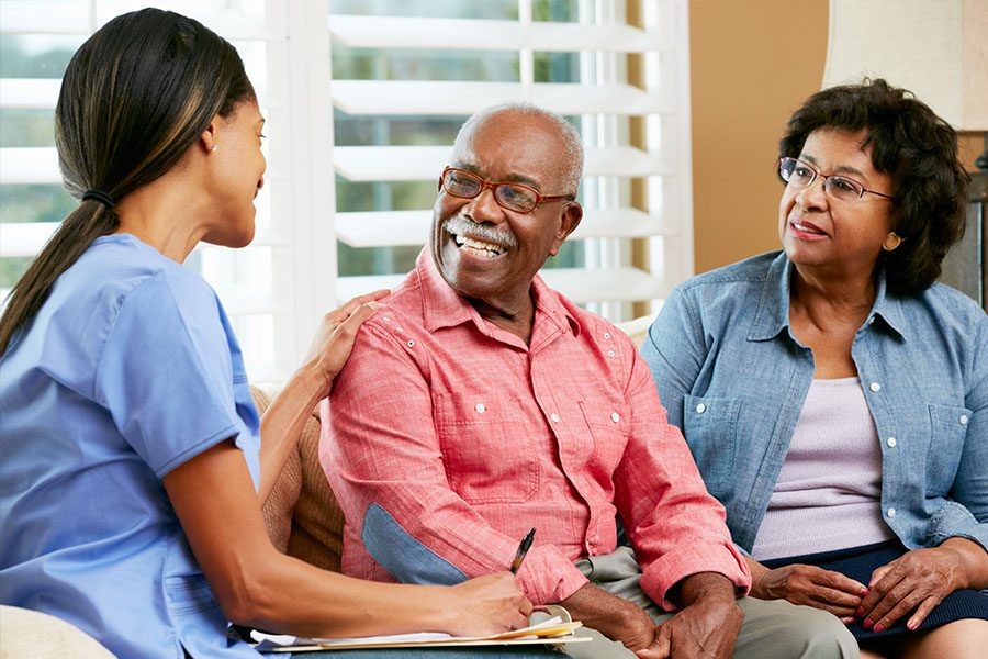 Healthcare Operations Insurance - Home Nurse Meeting with Older Couple in the Living Room